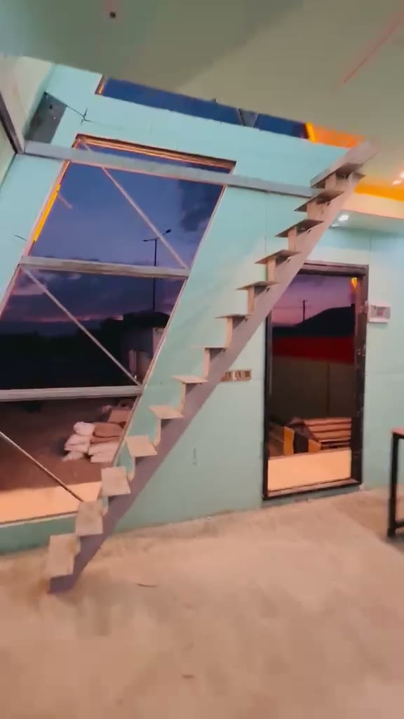 Staircase beside full-height glazing at dusk