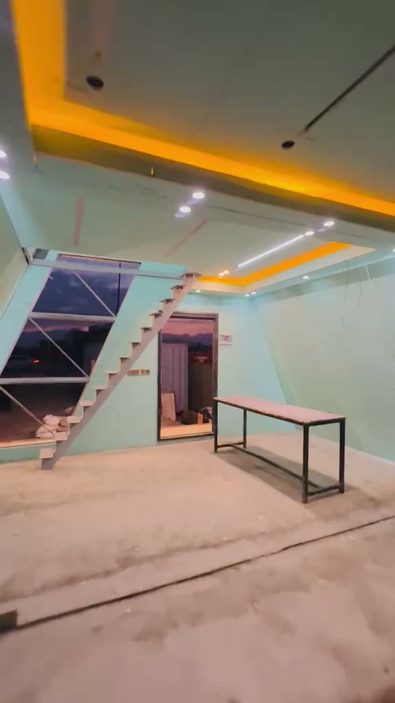 Floating staircase inside the A-frame with sunset visible through the triangular glazed wall